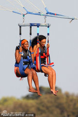 组图：蕾哈娜与好友玩跳伞 白色比基尼大秀身材