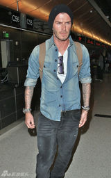 幻灯：贝克汉姆神情严肃飞抵伦敦 大秀两臂纹身