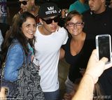 组图：比伯白衫现身机场 抱BB吻粉丝表现亲切