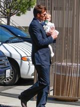 组图：邦辰穿小花裤外出 怀抱萌娃细心用手遮阳