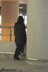 组图：周迅抵沪甩头发玩飘逸 倚栏听歌显落寞