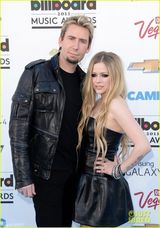 组图：艾薇儿携未婚夫恩爱亮相 黑色潮装似特工