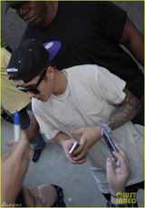 组图：比伯秀新玫瑰纹身与粉丝合照摆酷