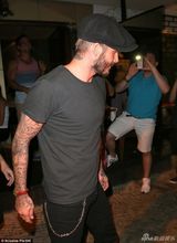 组图：小贝现身机场亲自推行李 皮衣帅气引围观