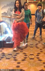 组图：杨幂拍新片穿纸拖鞋换装 自抱裙摆遮孕肚