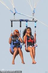 组图：蕾哈娜与好友玩跳伞 白色比基尼大秀身材