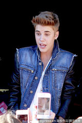 组图：比伯当街献唱谢歌迷 小天王自恋摸发