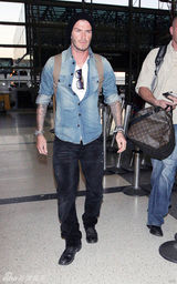 幻灯：贝克汉姆神情严肃飞抵伦敦 大秀两臂纹身