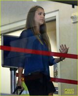 组图：阿尔芭憔悴亮相机场 肩夹手机忙通话