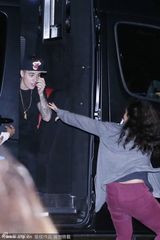 组图：比伯遇女粉丝追车拉手不放 V字手势告别