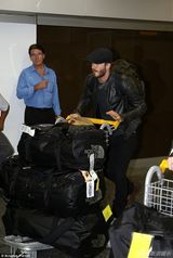 组图：小贝现身机场亲自推行李 皮衣帅气引围观