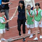 组图：张曼玉笑眯眯进校园做公益 与小粉丝亲切握手