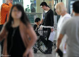 组图：黄晓明与陈可辛同机回京 坐轮椅空乘护送