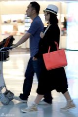 组图：秦海璐机场逛品牌店 获工作人员帮推行李