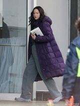 组图：劳伦斯披紫袄现身片场 素颜显知性气质