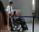 组图：斯琴高娃坐轮椅现身机场 工作人员帮搭飞机