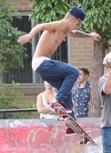 组图：比伯半裸玩滑板秀纹身 裤子滑落露小内