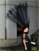 组图：Gaga戴超大孔雀头饰艰难上车俯身露乳