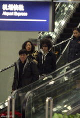 幻灯图：刘晓庆易钢演出归来 阿峰机场笑脸相迎