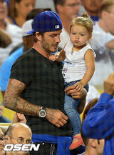 组图：小贝化身奶爸哄女儿 小七捏脸抢帽玩老爸