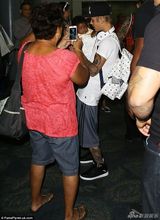 组图：比伯白衫现身机场 抱BB吻粉丝表现亲切