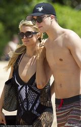 组图：希尔顿与男友海滩漫步 穿渔网装胸部外扩