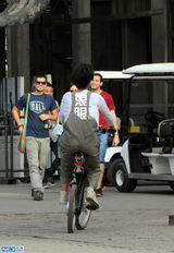 组图：张歆艺798独自骑车游玩 摘花折枝心情好